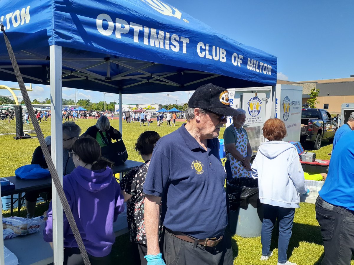 Optimists volunteering at a Track and Field event bbqing and serving food